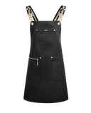 A black bib apron with gold-tone hardware, featuring a central chest pocket, two lower front pockets with gold zipper pulls, and adjustable shoulder straps with gold metal clasps, shown on a plain white background.