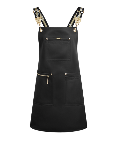 A black bib apron with gold-tone hardware, featuring a central chest pocket, two lower front pockets with gold zipper pulls, and adjustable shoulder straps with gold metal clasps, shown on a plain white background.