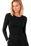 Close-up of model wearing the BLACKPANTS Essential Layering Top in black, featuring a boat neckline, long sleeves and body-skimming stretch fit