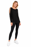 Full-length view of model wearing the BLACKPANTS Open Shoulder Drape Top in black styled with black leggings and white sneakers